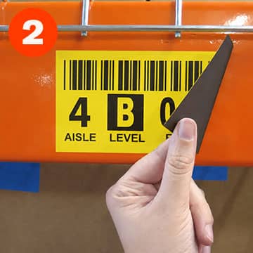 Hand repositioning a magnetic rack label