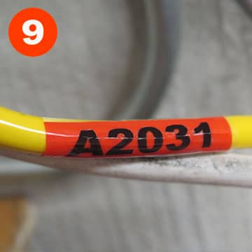 Self-laminating wire wrap label on a cable