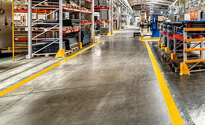 Wide warehouse aisleway marked with yellow floor marking tape