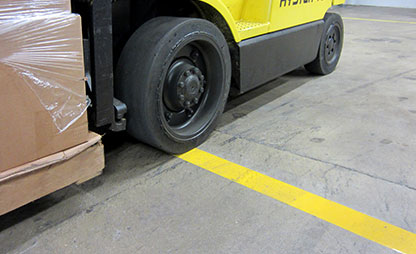 Forklift drives over floor marking tape