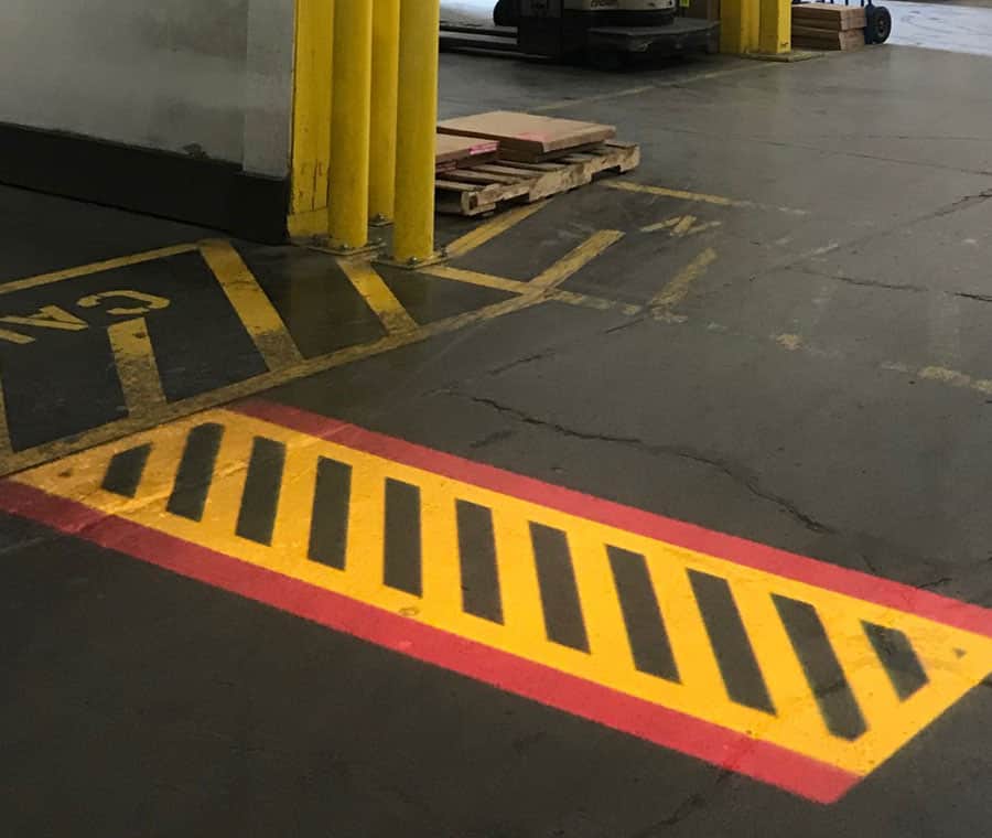 SignCast Virtual Sign projecting crosswalk lines on warehouse floor